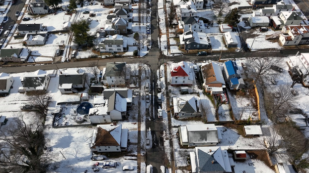 Aerial view of a quiet residential neighborhood with snow covered rooftops bare trees and clear streets in Lynchburg Virginia United States. Aerial view of a quiet residential neighborhood with snow covered rooftops bare trees and clear streets in Lynchburg Virginia United States.