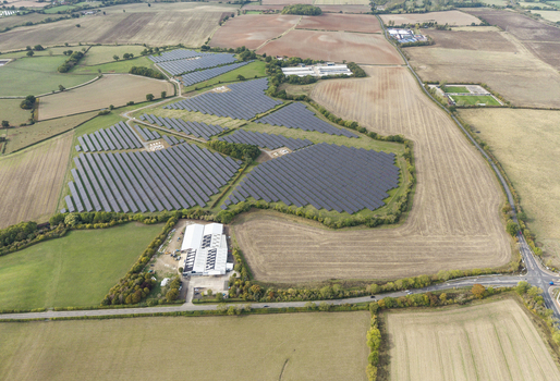 Aerial view of Chesterton Solar Farm featuring rows of photovoltaic panels installed in rural fields surrounded by agricultural land and hedgerows in Warwickshire United Kingdom. Aerial view of Chesterton Solar Farm featuring rows of photovoltaic panels installed in rural fields surrounded by agricultural land and hedgerows in Warwickshire United Kingdom.