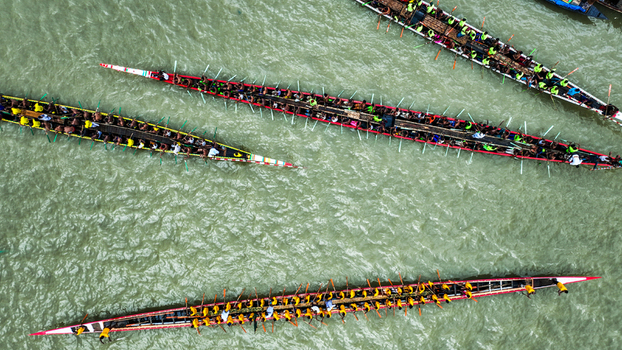 Baghabari Rajshahi Division Bangladesh 20 August 2022 Aerial view of long racing boats filled with rowers competing on the river showcasing synchronized paddling.