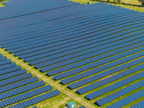 Aerial view of Lisburn Solar Farm with rows of photovoltaic panels arranged in a field under clear sky in Lisburn Northern Ireland United Kingdom. Aerial view of Lisburn Solar Farm with rows of photovoltaic panels arranged in a field under clear sky in Lisburn Northern Ireland United Kingdom.