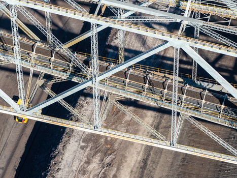Aerial view of the Tagebau Welzow Sud brown coal open pit mine showing the massive steel conveyor bridge structure spanning the dark earth of the mining site in Spremberg Brandenburg Germany. Aerial view of the Tagebau Welzow Sud brown coal open pit mine showing the massive steel conveyor bridge structure spanning the dark earth of the mining site in Spremberg Brandenburg Germany.