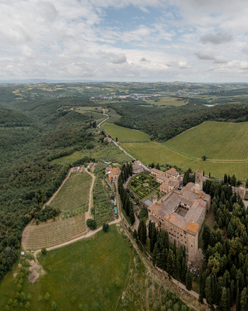 Aerial view of the historic Abbazia di Passignano surrounded by lush vineyards cypress trees and the rolling hills of the Tuscan countryside in Passignano Toscana Italy. Aerial view of the historic Abbazia di Passignano surrounded by lush vineyards cypress trees and the rolling hills of the Tuscan countryside in Passignano Toscana Italy.