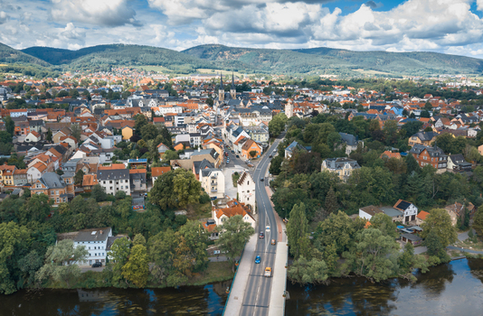 Aerial view of the historic town of Saalfeld with its church spires traditional rooftops and a bridge crossing the river surrounded by lush green hills in Saalfeld Thuringia Germany. Aerial view of the historic town of Saalfeld with its church spires traditional rooftops and a bridge crossing the river surrounded by lush green hills in Saalfeld Thuringia Germany.