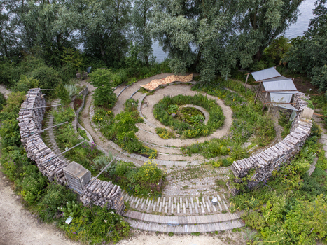 Aerial view of a spiral garden structure with wooden steps and lush greenery a tranquil escape nestled amidst trees Utopia Flevoland Netherlands.
