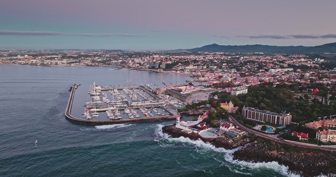Aerial view of Cascais Marina with its lighthouse docked boats and surrounding coastal buildings at sunset in Lisbon Lisbon Portugal. Aerial view of Cascais Marina with its lighthouse docked boats and surrounding coastal buildings at sunset in Lisbon Lisbon Portugal.