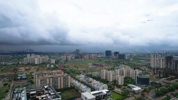 Aerial view of Gurugram skyscrapers and green fields India.
