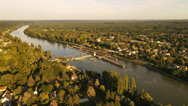 Aerial view of the Seine river lock in Chartrettes surrounded by lush forests and residential houses in Chartrettes Ile de France France. Aerial view of the Seine river lock in Chartrettes surrounded by lush forests and residential houses in Chartrettes Ile de France France.