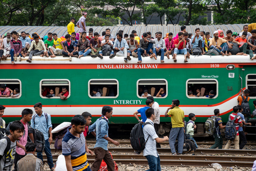Dhaka Bangladesh 15 June 2018 View of a crowded Bangladesh Railway intercity train with many people sitting on the roof and standing on the tracks at Airport Railway Station. Dhaka Bangladesh 15 June 2018 View of a crowded Bangladesh Railway intercity train with many people sitting on the roof and standing on the tracks at Airport Railway Station.