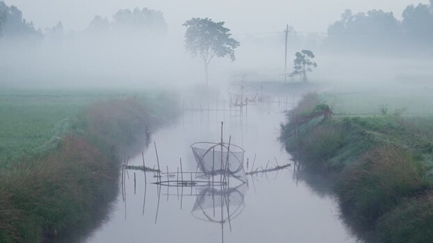 View of traditional fishing nets in a misty river Bangladesh.