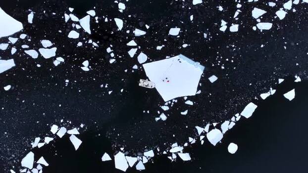 Aerial view of a boat by an ice floe in arctic waters Greenland. Aerial view of a boat by an ice floe in arctic waters Greenland.