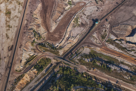 Aerial view of the lignite open cast mine Schleenhain showing extensive excavation patterns dirt roads industrial tracks and sparse vegetation in Zwenkau Saxony Germany.