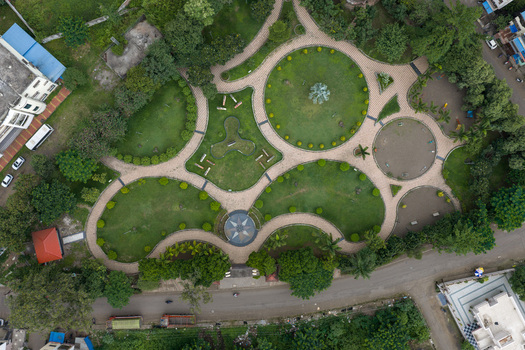 Aerial view of a public park in Karad featuring circular pathways lush green lawns and manicured trees Karad Maharashtra India.
