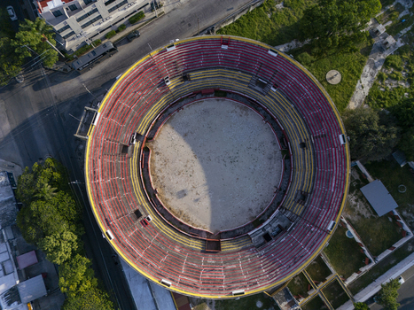 Aerial view of Plaza De Toros Merida a historic bullring with circular seating and a sandy arena surrounded by urban streets and greenery in Merida Yucatan Mexico. Aerial view of Plaza De Toros Merida a historic bullring with circular seating and a sandy arena surrounded by urban streets and greenery in Merida Yucatan Mexico.