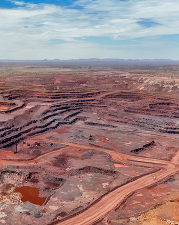 Aerial view of an open cast mining operation with deep excavations terraced slopes and red earth showing the scale of mineral extraction in Northam Limpopo South Africa. Aerial view of an open cast mining operation with deep excavations terraced slopes and red earth showing the scale of mineral extraction in Northam Limpopo South Africa.