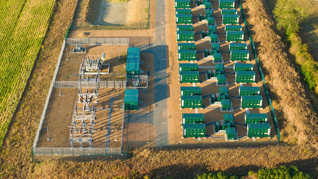 Aerial view of the Battery Energy Storage System at BESS Grendon featuring rows of green battery containers and electrical substation equipment in Northampton England United Kingdom. Aerial view of the Battery Energy Storage System at BESS Grendon featuring rows of green battery containers and electrical substation equipment in Northampton England United Kingdom.