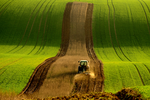 View of a tractor plowing a field in the rolling hills of Moravia in Brno City District South Moravian Region Czechia.