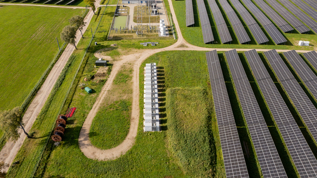 Aerial view of a battery energy storage system at a solar farm with rows of photovoltaic panels in Poland. Aerial view of a battery energy storage system at a solar farm with rows of photovoltaic panels in Poland.