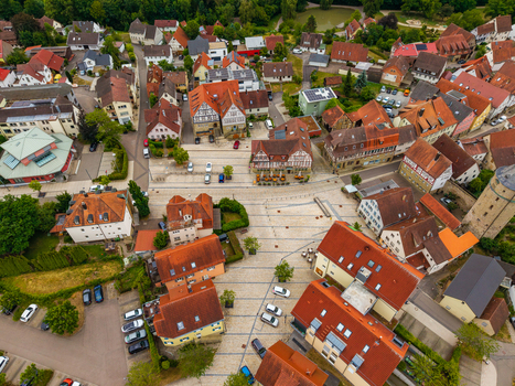 Aerial view of Neuenstein Castle and the surrounding historic town square with traditional half timbered houses cobblestone streets and lush green trees in Neuenstein Baden Wurttemberg Germany. Aerial view of Neuenstein Castle and the surrounding historic town square with traditional half timbered houses cobblestone streets and lush green trees in Neuenstein Baden Wurttemberg Germany.
