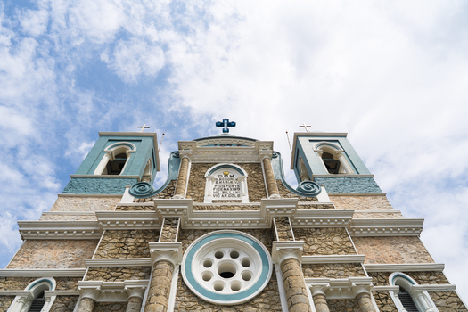 View of the historic St. Mary s Cathedral with stone walls and blue architectural details under a cloudy sky in Galle Southern Province Sri Lanka.