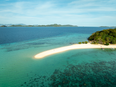 Aerial view of Malcapuya Island featuring a pristine white sand beach turquoise waters vibrant coral reefs and lush tropical vegetation in Coron Mimaropa Philippines. Aerial view of Malcapuya Island featuring a pristine white sand beach turquoise waters vibrant coral reefs and lush tropical vegetation in Coron Mimaropa Philippines.