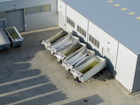 Aerial view of empty semi trailers parked in a row outside a modern industrial warehouse facility with numbered loading bays in Krakow Lesser Poland Voivode Poland. Aerial view of empty semi trailers parked in a row outside a modern industrial warehouse facility with numbered loading bays in Krakow Lesser Poland Voivode Poland.