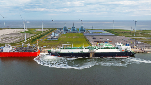 Aerial view of the LNG terminal in Eemshaven featuring a large liquefied natural gas tanker docked at the pier industrial infrastructure and wind turbines in Eemshaven Groningen Netherlands. Aerial view of the LNG terminal in Eemshaven featuring a large liquefied natural gas tanker docked at the pier industrial infrastructure and wind turbines in Eemshaven Groningen Netherlands.