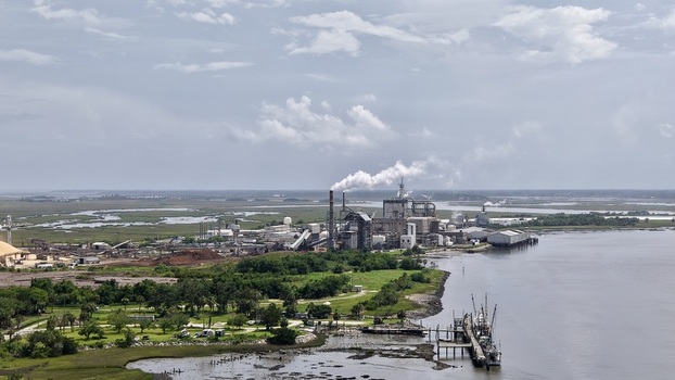 Aerial view of a sprawling industrial complex with towering smokestacks emitting plumes contrasting with the serene marshlands and dark waters Fernandina Beach Florida United States. Aerial view of a sprawling industrial complex with towering smokestacks emitting plumes contrasting with the serene marshlands and dark waters Fernandina Beach Florida United States.