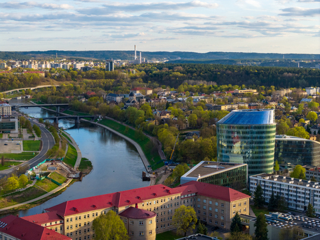 Aerial view of the Neris river winding through the urban landscape with modern glass buildings and historic red roofed structures Vilnius County Lithuania. Aerial view of the Neris river winding through the urban landscape with modern glass buildings and historic red roofed structures Vilnius County Lithuania.