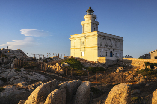 View of the historic Capo Testa Lighthouse perched on granite rocks under a clear blue sky at sunset Capo Testa Sardegna Italy. View of the historic Capo Testa Lighthouse perched on granite rocks under a clear blue sky at sunset Capo Testa Sardegna Italy.