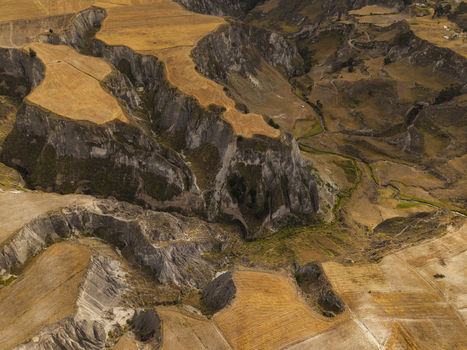 Aerial view of the dramatic Toachi River Canyon featuring steep rocky cliffs golden agricultural fields and winding terrain in Zumbahua Cotopaxi Ecuador. Aerial view of the dramatic Toachi River Canyon featuring steep rocky cliffs golden agricultural fields and winding terrain in Zumbahua Cotopaxi Ecuador.