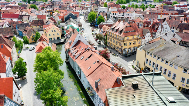 Aerial view of the historic old town featuring red tiled roofs and a narrow canal flowing between traditional buildings in Forchheim Bavaria Germany. Aerial view of the historic old town featuring red tiled roofs and a narrow canal flowing between traditional buildings in Forchheim Bavaria Germany.
