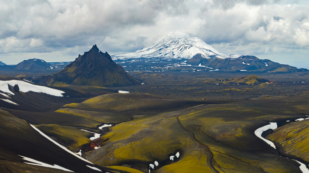 Aerial view of Krakatindur mountain with snow capped peaks and mossy volcanic landscape in Rangarthing ytra Iceland. Aerial view of Krakatindur mountain with snow capped peaks and mossy volcanic landscape in Rangarthing ytra Iceland.
