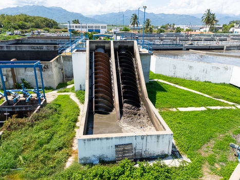 Aerial view of water treatment plant with screw pumps and concrete structures set against a backdrop of distant mountains Puerto Vallarta Mexico. Aerial view of water treatment plant with screw pumps and concrete structures set against a backdrop of distant mountains Puerto Vallarta Mexico.