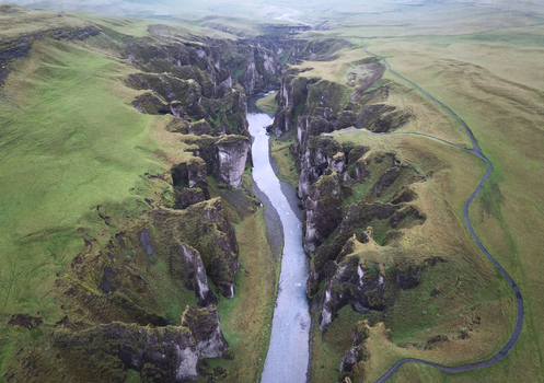 Aerial view of Fjadrargljufur canyon with its steep mossy cliffs and the winding Fjadra river flowing through the valley Skaftarhreppur Iceland. Aerial view of Fjadrargljufur canyon with its steep mossy cliffs and the winding Fjadra river flowing through the valley Skaftarhreppur Iceland.