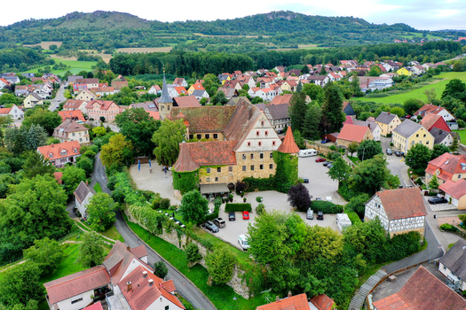 Wiesenthau Germany 09 May 2026 Aerial view of Schloss Wiesenthau with its historic stone walls ivy covered towers and red tiled roofs nestled in the village landscape. Wiesenthau Germany 09 May 2026 Aerial view of Schloss Wiesenthau with its historic stone walls ivy covered towers and red tiled roofs nestled in the village landscape.