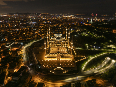 Aerial view of Grand Camlica Mosque illuminated at night surrounded by the sprawling city lights of Uskudar Istanbul Turkiye. Aerial view of Grand Camlica Mosque illuminated at night surrounded by the sprawling city lights of Uskudar Istanbul Turkiye.