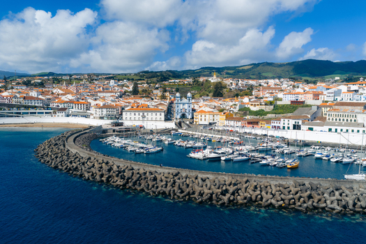 Aerial view of the harbor with sailboats the blue Igreja da Misericordia church and colorful coastal architecture in Angra do Heroismo Azores Portugal.
