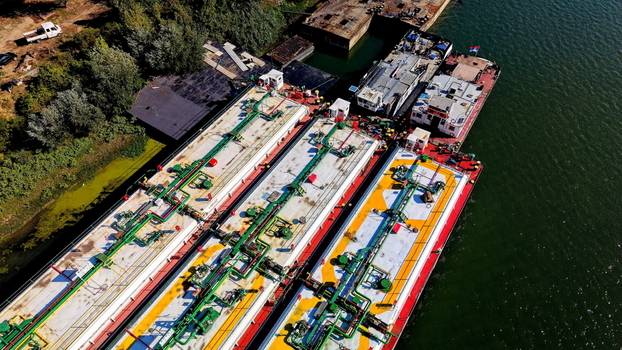 Aerial view of Smederevo shipyard with industrial barges docked along the Danube river featuring complex piping systems and colorful decks in Smederevo Podunavlje District Serbia. Aerial view of Smederevo shipyard with industrial barges docked along the Danube river featuring complex piping systems and colorful decks in Smederevo Podunavlje District Serbia.