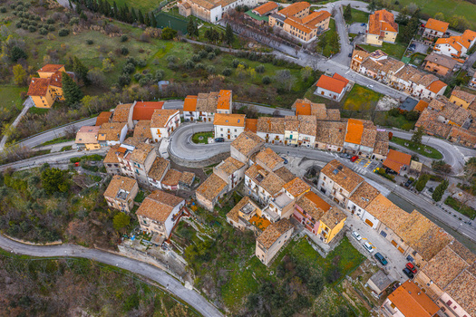 Aerial view of the historic village featuring terracotta rooftops and a winding road surrounded by greenery Pacentro Abruzzo Italy. Aerial view of the historic village featuring terracotta rooftops and a winding road surrounded by greenery Pacentro Abruzzo Italy.