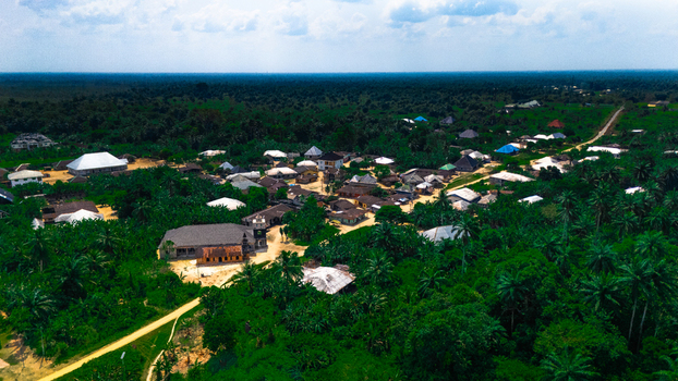 Aerial view of the village of Abua featuring small houses with metal roofs dirt paths and dense tropical vegetation in Abua Rivers Nigeria. Aerial view of the village of Abua featuring small houses with metal roofs dirt paths and dense tropical vegetation in Abua Rivers Nigeria.