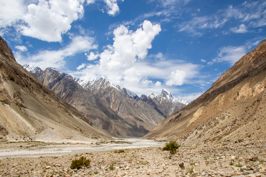 View of the rugged mountain landscape near K2 Base Camp featuring snow capped peaks rocky slopes and a clear blue sky in Gilgit Baltistan Pakistan. View of the rugged mountain landscape near K2 Base Camp featuring snow capped peaks rocky slopes and a clear blue sky in Gilgit Baltistan Pakistan.
