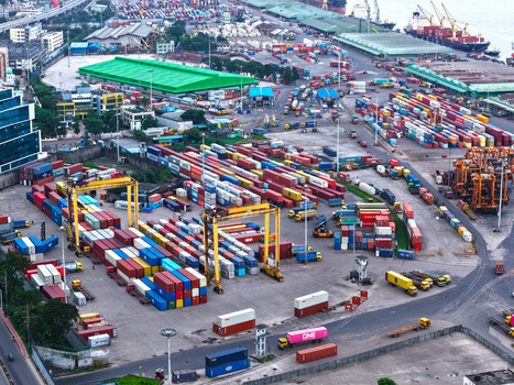 Aerial view of Chattogram Port featuring rows of colorful shipping containers gantry cranes and trucks in a busy industrial terminal in Chittagong Chittagong Division Bangladesh.