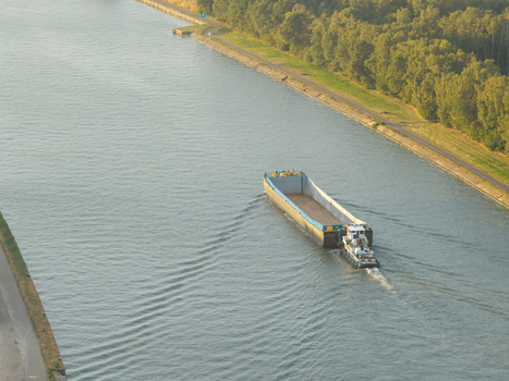 Aerial view of a barge navigating the Albert Canal through the industrial landscape of Genk Vlaanderen Belgium.