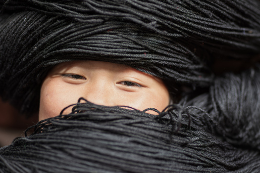 Gaoxing China 29 April 2026 View of a Long Horn Miao girl wearing a traditional massive black yarn headdress that partially covers her face. Gaoxing China 29 April 2026 View of a Long Horn Miao girl wearing a traditional massive black yarn headdress that partially covers her face.