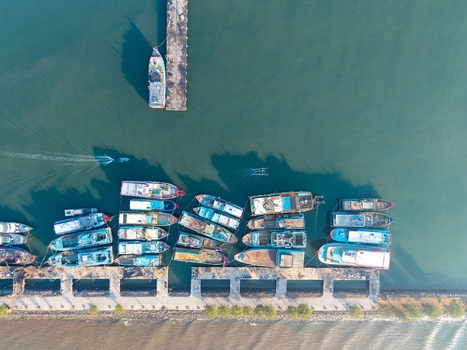 Aerial view of fishing boats moored at a concrete pier in the harbor of Probolinggo East Java Indonesia.