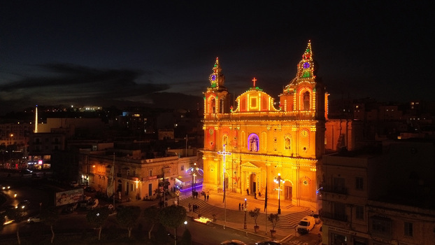 Aerial view of an illuminated church facade decorated with festive lights at night in the city center of Valletta Port Region Malta. Aerial view of an illuminated church facade decorated with festive lights at night in the city center of Valletta Port Region Malta.