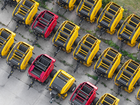 Plock Poland 10 September 2026 Aerial view of rows of yellow and red agricultural balers parked at a harvesting machinery manufacturing facility. Plock Poland 10 September 2026 Aerial view of rows of yellow and red agricultural balers parked at a harvesting machinery manufacturing facility.