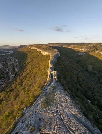 Aerial view of Ovech Fortress on a narrow stone plateau overlooking the town surrounded by lush green hills and warm golden hour light in Provadia Varna Bulgaria. Aerial view of Ovech Fortress on a narrow stone plateau overlooking the town surrounded by lush green hills and warm golden hour light in Provadia Varna Bulgaria.