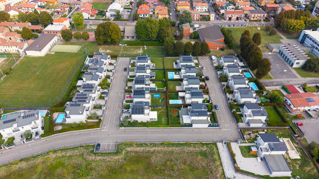 Aerial view of modern residential houses featuring private gardens swimming pools and rooftop solar panels in a suburban neighborhood in Milan Lombardy Italy. Aerial view of modern residential houses featuring private gardens swimming pools and rooftop solar panels in a suburban neighborhood in Milan Lombardy Italy.