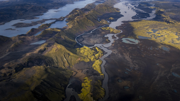 Aerial view of Langisjor lake surrounded by volcanic mountains mossy green slopes and winding river channels in the rugged landscape of Vik Skaftarhreppur Iceland. Aerial view of Langisjor lake surrounded by volcanic mountains mossy green slopes and winding river channels in the rugged landscape of Vik Skaftarhreppur Iceland.